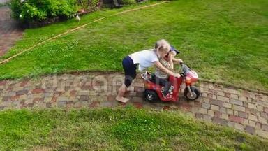 两个可爱的金发碧眼的孩子在花园小径上玩<strong>电动玩具</strong>自行车。 兄弟姐妹享受